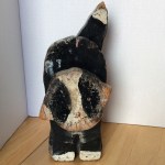 Photo of a wooden doorstop in the shape of a cat.